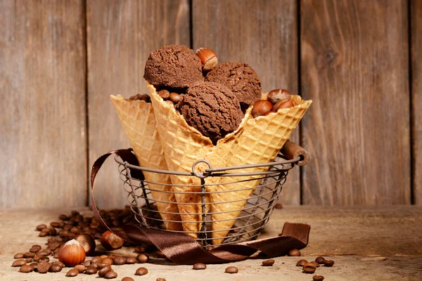 Sabroso helado de chocolate en cono de gofre sobre fondo de madera marrón —  Fotos de Stock