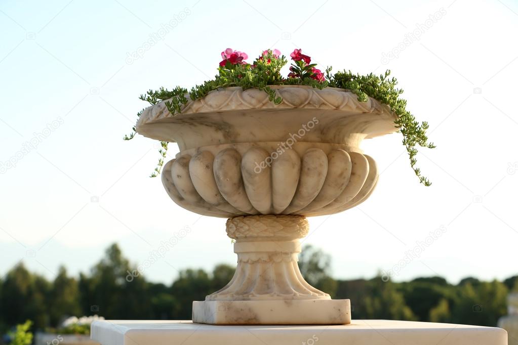 Stone planter with flowers in garden