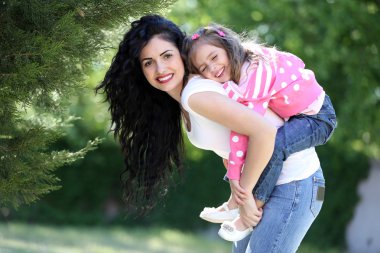 Щаслива мама і дочка. ходити в зеленому парку