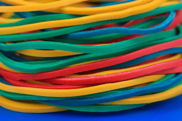 Bandas de goma de colores sobre fondo azul de cerca — Foto de Stock