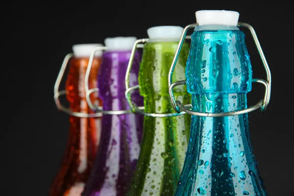 Botellas de colores sobre fondo negro — Foto de Stock