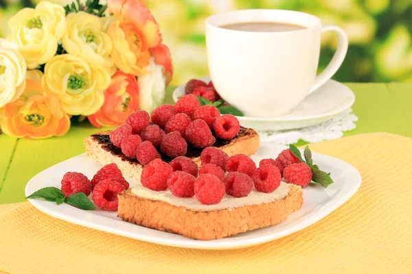 Köstliche Toast mit Himbeeren auf dem Tisch auf hellem Hintergrund — Stockfoto