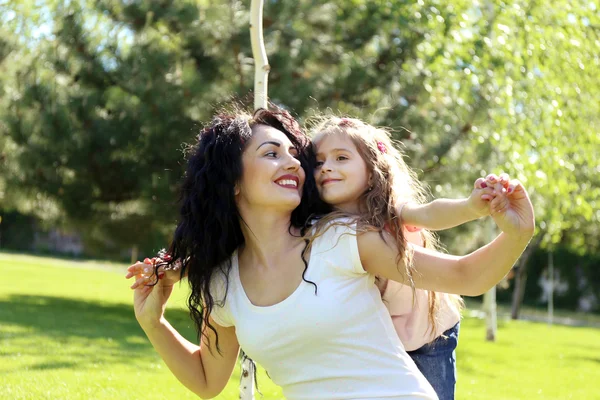 Feliz mamá y su hija. Caminar por el parque verde — Foto de Stock