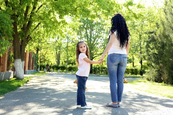 Ibu dan anak yang bahagia. Berjalan di taman hijau — Stok Foto