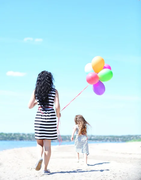 Happy mom and daughter on the beach — Stock Photo, Image