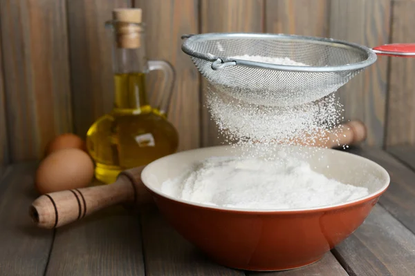 Sifting flour into bowl — Stock Photo, Image
