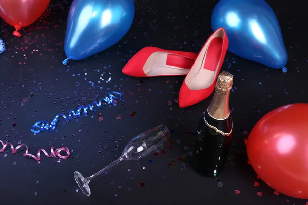 Schuhe mit Konfetti, Champagner und Luftballons am Boden — Stockfoto