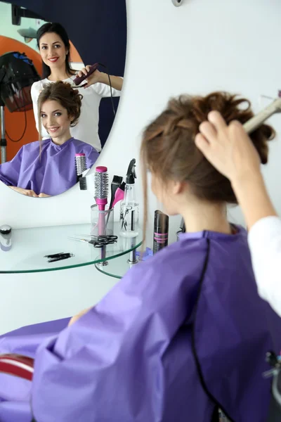 Молодая женщина парикмахер сделать прическу девушка в салоне красоты — стоковое фото
