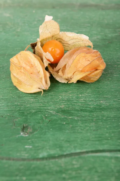 Frutas Physalis sobre fondo de madera verde —  Fotos de Stock