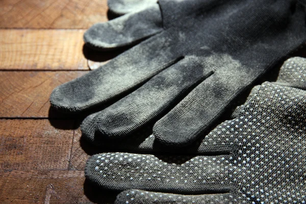 Βρώμικο ύφασμα χρησιμοποιούνται γάντια σε ξύλινα φόντο — Φωτογραφία Αρχείου