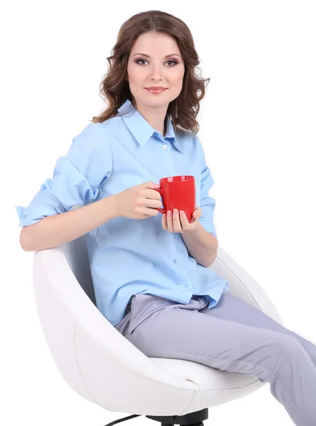 Joven mujer de negocios sentada en silla con taza aislada en blanco — Foto de Stock