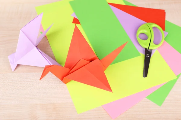 Guindaste de Origami e papel sobre mesa de madeira — Fotografia de Stock