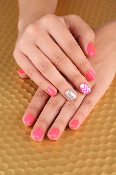 Vrouwelijke hand met stijlvolle kleurrijke nagels, op lichte achtergrond — Stockfoto