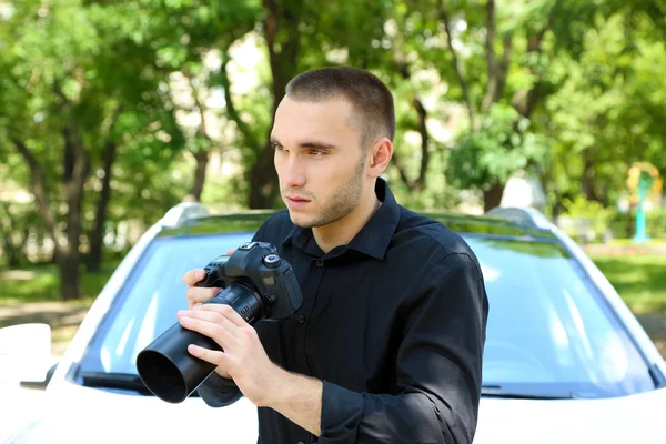 Homem perto do carro com câmera de foto — Fotografia de Stock