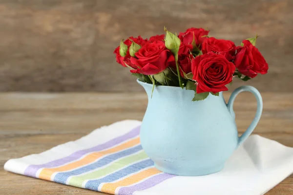 Bouquet di rose rosse in vaso su fondo di legno — Foto Stock