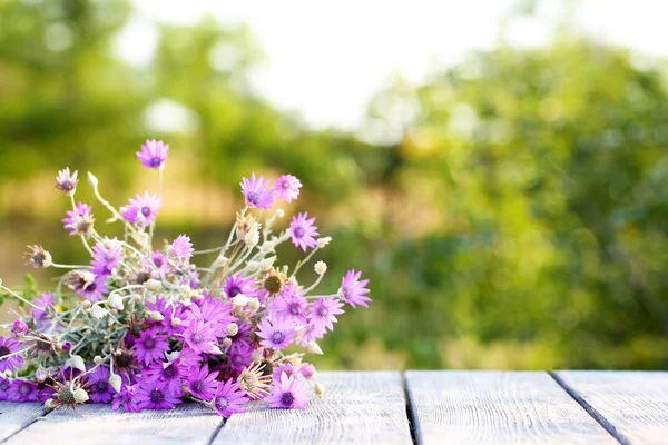 Beautiful wild flowers on table on bright background — Stock Photo, Image