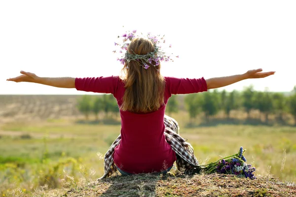 Beautiful girl sitting on haystack in field — Stock Photo, Image