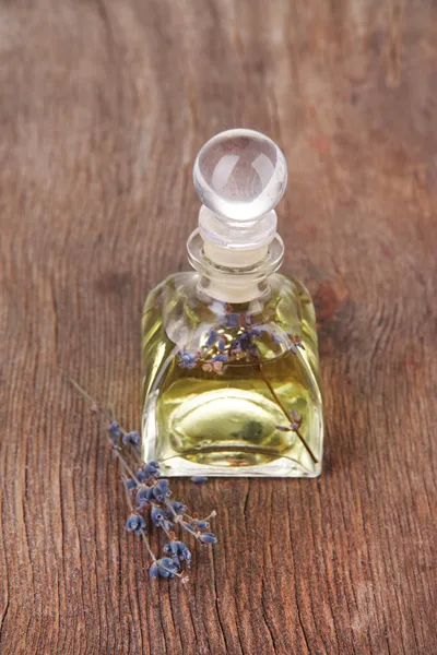 Lavender oil with flowers on wooden table — Stock Photo, Image