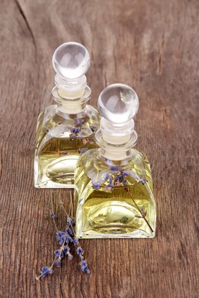 Levandulový olej s květinami na dřevěný stůl — Stock fotografie