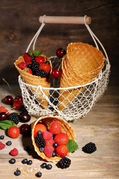 Different ripe berries in sugar cones Royalty Free Stock Photos