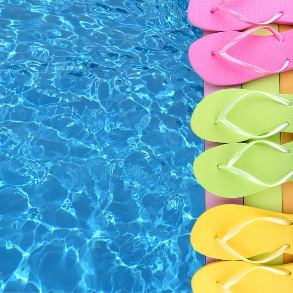 Colored flip flops on wooden platform beside sea — Stock Photo, Image