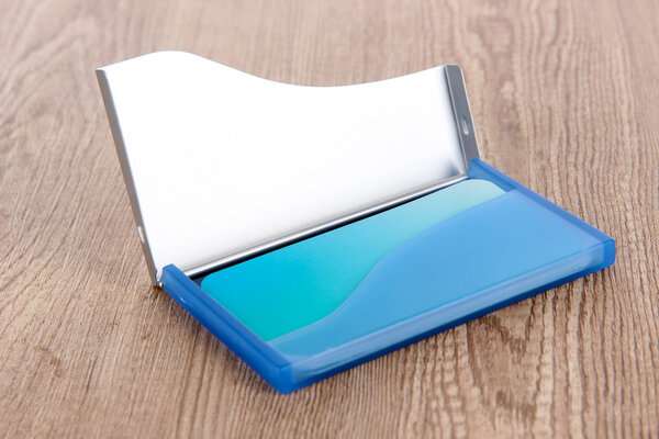 Держатель голубой визитки на деревянном фоне
