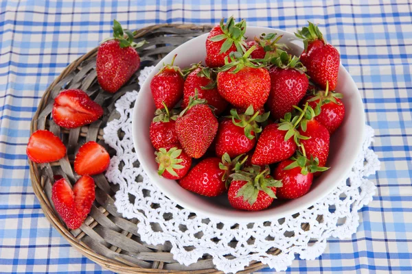 Fresas en plato sobre soporte de mimbre sobre servilleta — Foto de Stock