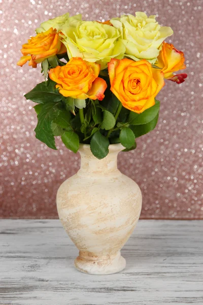 Beautiful bouquet of roses in vase on table on brown background — Stock Photo, Image