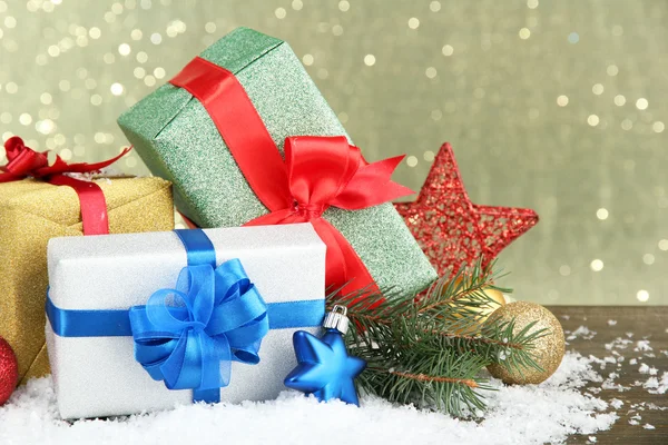 Bellissimi regali luminosi e decorazioni natalizie, su sfondo lucido — Foto Stock
