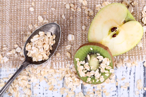 Apple, kiwi fruit with oatmeal — Stock Photo, Image