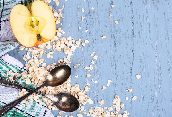 Apple with oatmeal and vintage spoons — Stock Photo, Image