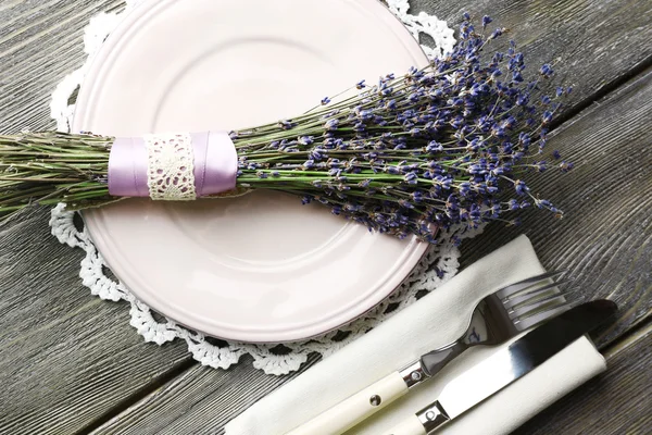 Apparecchiatura tavolo da pranzo con fiori di lavanda su sfondo tavolo di legno — Foto Stock