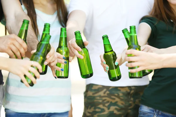 Mãos segurando garrafas de cerveja de perto — Fotografia de Stock