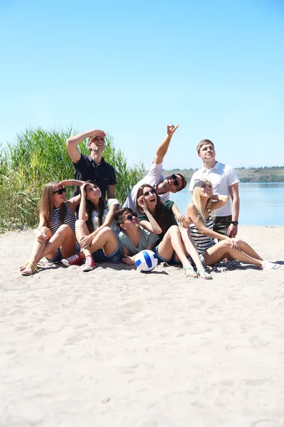 Groep vrienden met bal op strand — Stockfoto