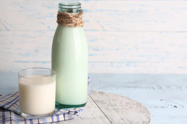 Glass bottle of milk on wooden background — Stock Photo, Image