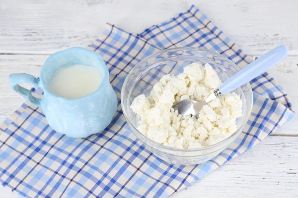 Coupe de lait et fromage cottage dans un bol en verre sur fond en bois — Photo