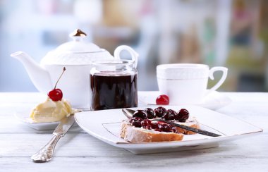 kiraz reçeli ve plaka üzerinde parlak zemin üzerine ahşap masa üzerine ev yapımı tereyağı ile taze ekmek