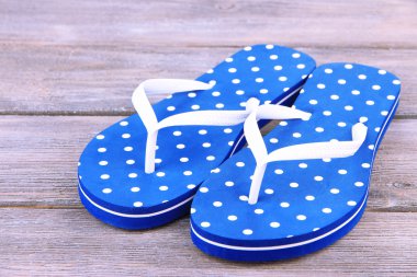 ahşap arka plan üzerinde renkli parmak arası terlik