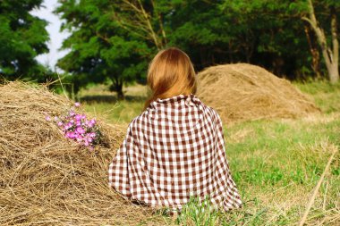 Samanlık alanında oturup güzel bir kız