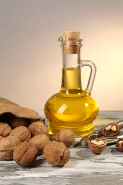 Walnut oil and nuts on wooden table — Stock Photo, Image