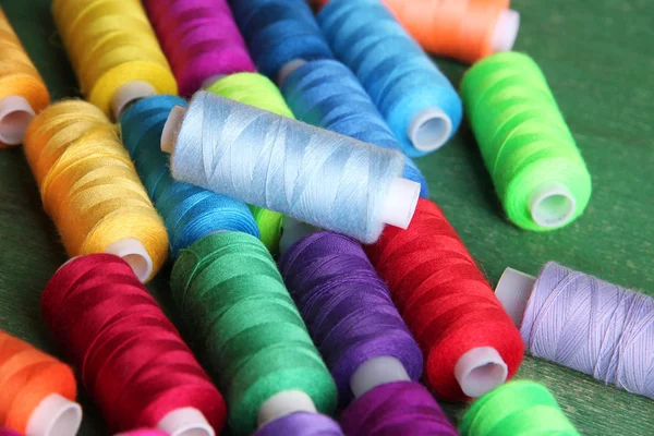 Multicolor sewing threads on wooden background — Stock Photo, Image