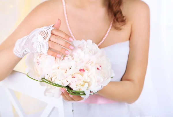 Bride holding wedding bouquet of white peonies, close-up, on light background — Stock Photo, Image