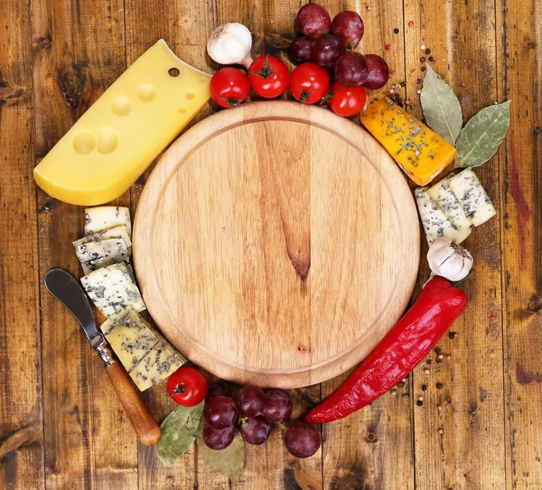 Verschiedene Käsesorten mit leerem Brett auf dem Tisch in Großaufnahme — Stockfoto