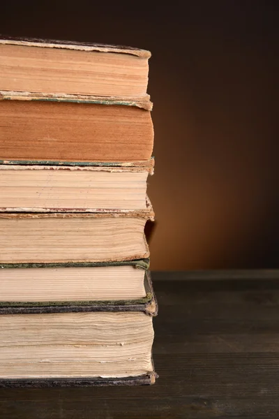 Oude boeken op tafel op bruine achtergrond — Stockfoto
