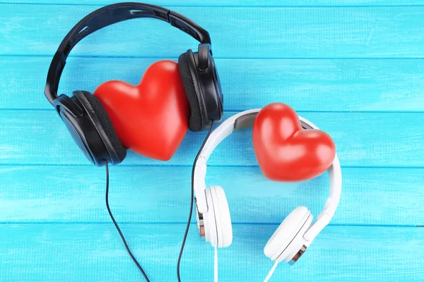 Headphones and hearts on wooden background — Stock Photo, Image