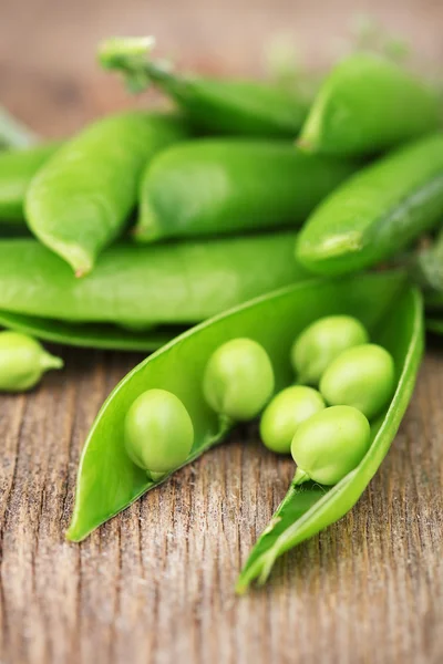 Guisantes verdes frescos en mesa de madera — Foto de Stock