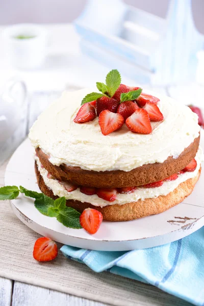 Delicious biscuit cake with strawberries on table close-up — Stock Photo, Image