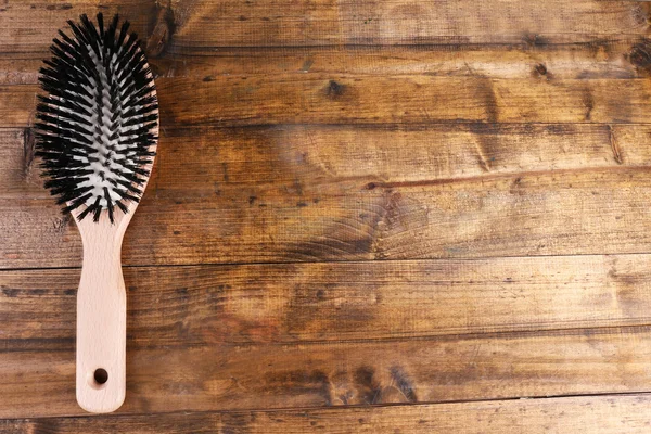 Brosse à cheveux en bois sur fond en bois — Photo