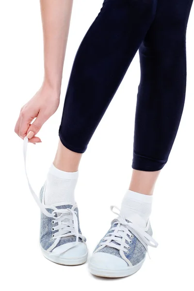 Young woman tying shoelace isolated on white — Stock Photo, Image