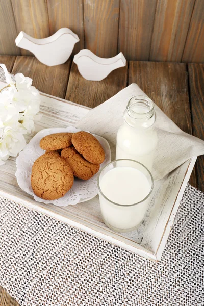 Leite e biscoitos na bandeja na mesa — Fotografia de Stock